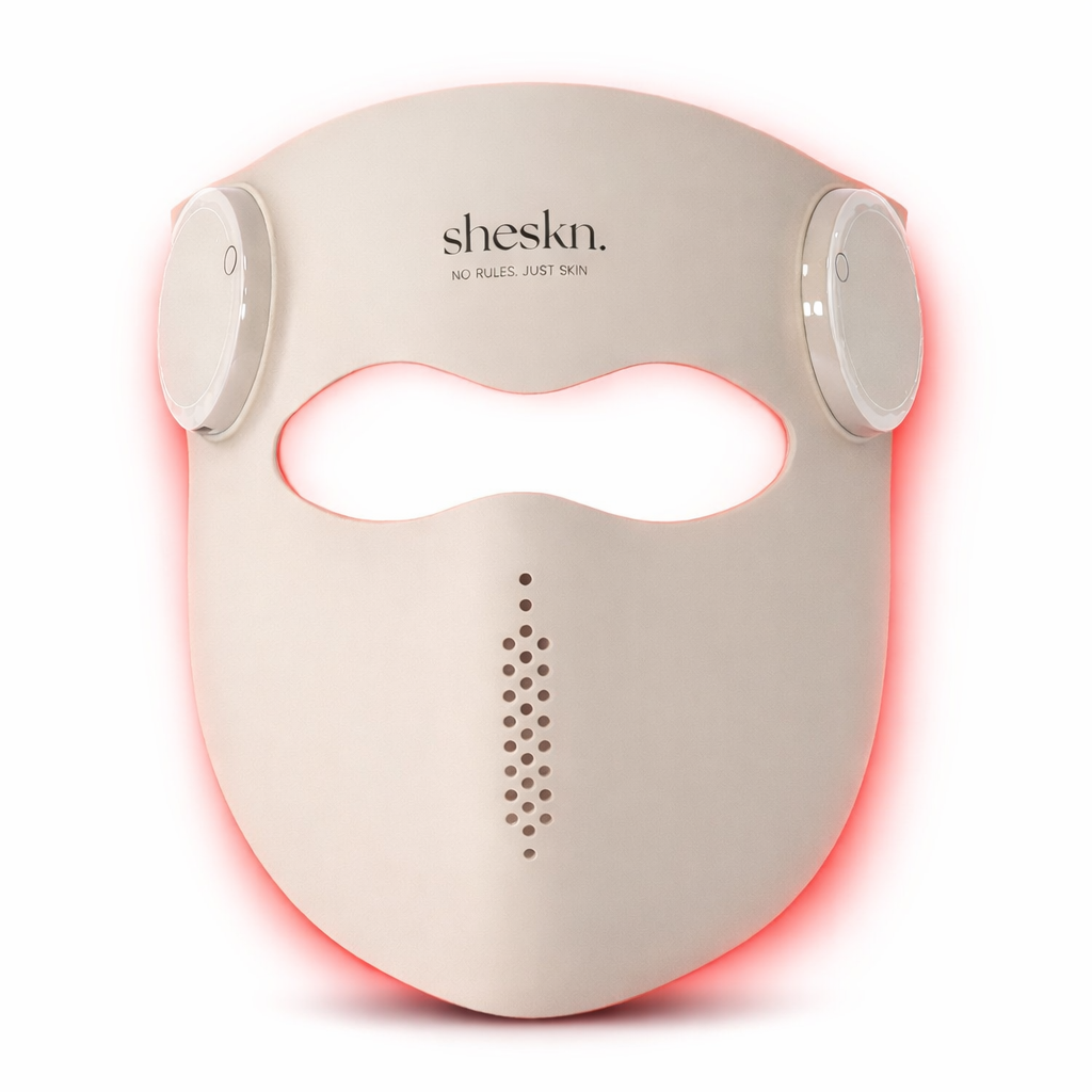 Beige Sheskn Luméskn LED face mask with subtle red light glow, shown on a white background