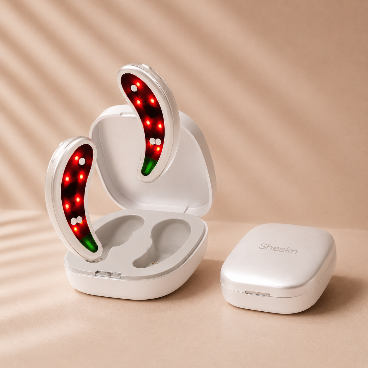Sheskn Eye Therapy LED and EMS under eye device displayed in an open white charging case with illuminated red light therapy pods on a soft beige neutral studio background.