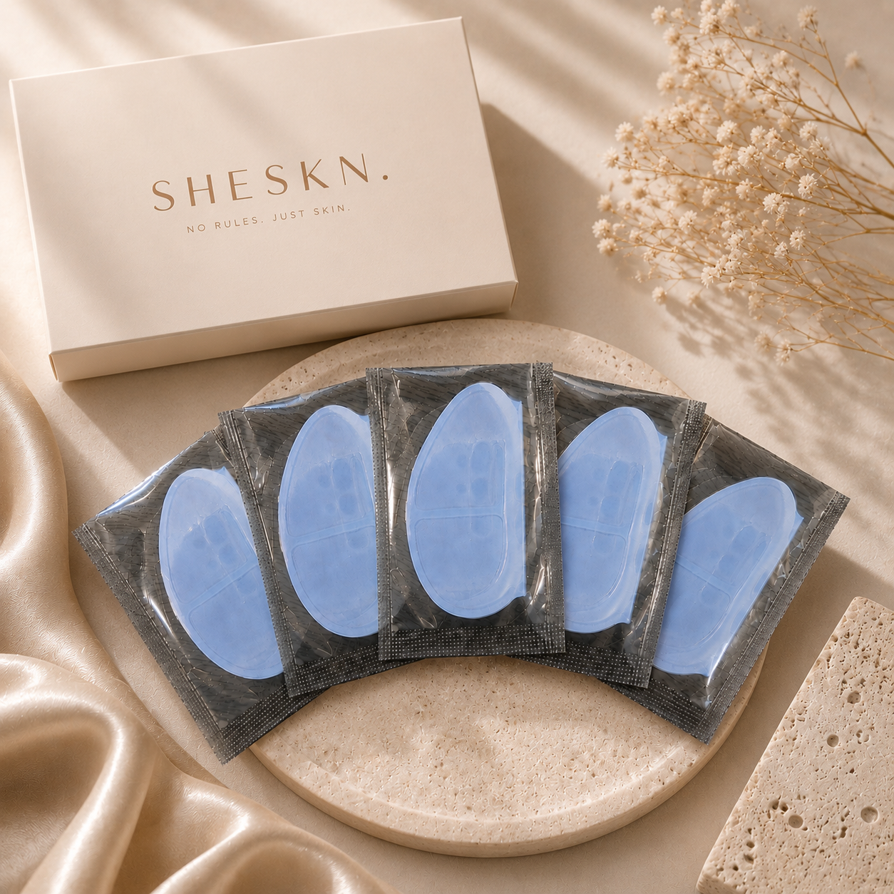 Five pairs of Sheskn Hydrogel Eye Patches displayed on a luxury neutral skincare background.